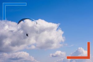 Person paragliding through the clouds, symbolizing data navigating multi-cloud environments with sovereignty and control