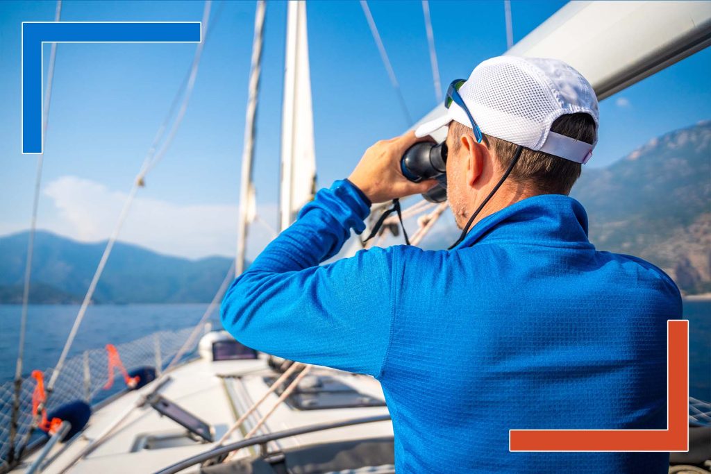 CXO using binoculars on a yacht to symbolize strategic vision and real-time decision intelligence with expert Power BI developers.